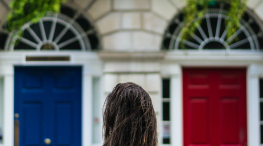 girl in front of red and blue door